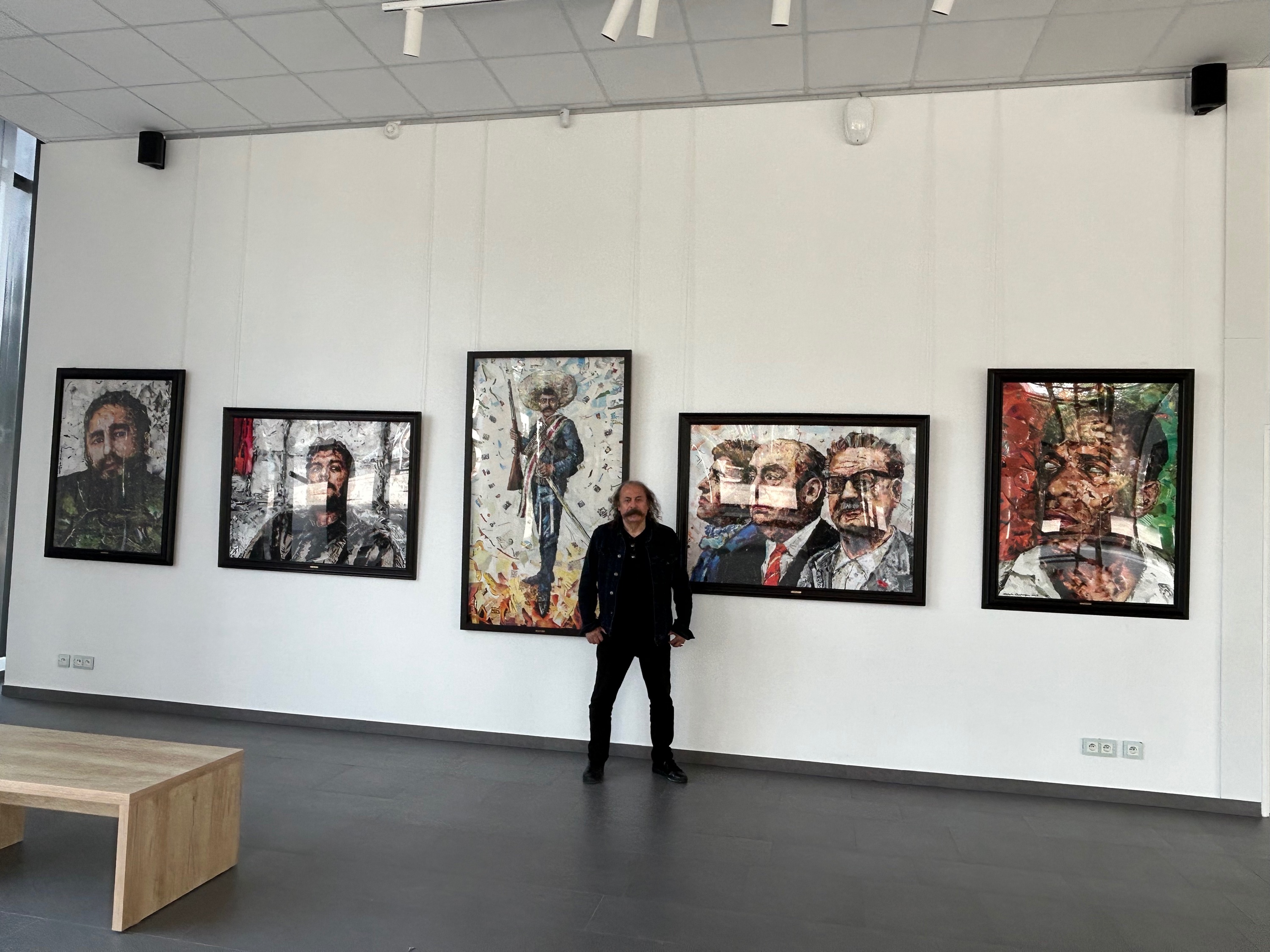 L'artiste devant ses portraits de Fidel Castro, Che Guevara, Zapata, Neruda/Allende/Victor Jara, Frantz Fanon)